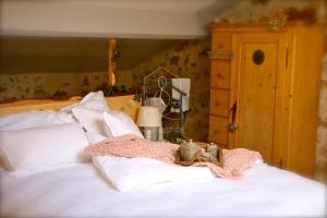 a bed with white sheets and a pink blanket on it at La Petite Maison d'Emmanuelle in Le Tignet