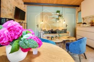 a living room with a table with pink flowers at La Petite Maison d'Emmanuelle in Le Tignet +1 photo