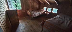 ein Zimmer mit zwei Betten in einer Holzhütte in der Unterkunft Cabañas y Casas Hualles in Coñaripe + 84 Fotos