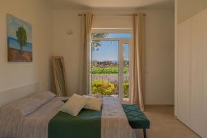 Un dormitorio con una cama y una ventana con vistas. en Villa Di Mola Egnazia and Pool, en Monopoli 61 fotos más