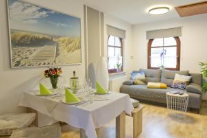 uma sala de estar com uma mesa e um sofá em Ferienwohnung Storchennest em Bad Liebenstein