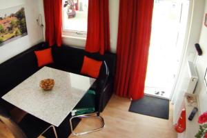a dining room with a table and red curtains at DÜSSELDORF - Haus am See mit Sandstrand nahe Rhein-Main und Spessart in Kahl am Main +25 photos
