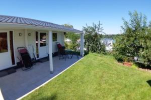 a house with a patio and a lawn at BARCELONA - Studio mit Sandstrand & Seeblick nahe Rhein-Main und Spessart in Kahl am Main