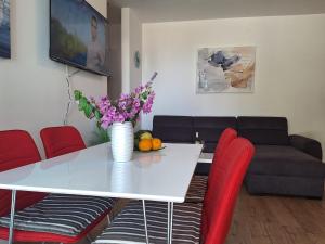a living room with a white table and red chairs at Villa Tea in Murter