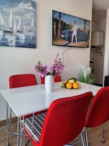 a dining room with a white table and red chairs at Villa Tea in Murter +8 photos
