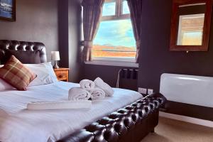 una camera da letto con un letto, asciugamani e una finestra di Argyll Hotel a Ullapool Altre 11 foto