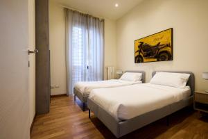 two beds in a hotel room with at Emme Loft I First Moon - Exclusive Design Apartment with balcony in Milan +10 photos