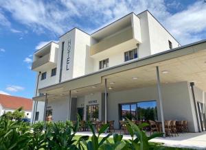 a large white building with tables and chairs at Hotel Telegraph in Oberwart