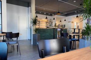 a restaurant with tables and chairs and a bar at Hotel Telegraph in Oberwart