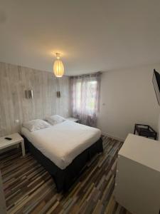 une chambre avec un lit et un lustre dans l'établissement Maison du manoir, à Bénouville