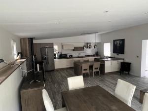 une cuisine et une salle à manger avec une table et des chaises dans l'établissement Maison du manoir, à Bénouville