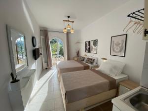 1 dormitorio con 2 camas y lavamanos en Ameli Studio ,Balcony with Mountain View, Kitchenette, 1km to Beach by likeyourhome, en Corfu