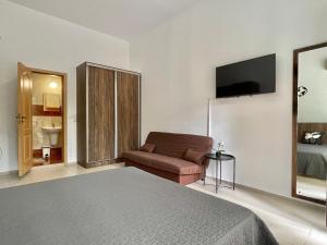 a bedroom with a bed and a couch and a television at Green Fort Noks - Private apartment - BSR - 3 in Sunny Beach