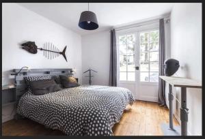 a bedroom with a bed and a large window at Agréable, jardin, toute équipée, proche du marché, plage à 300m in La Baule