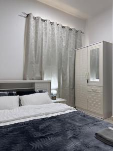 a bedroom with a large bed and a dresser at Cozy Studio Retreat in Al Ain in Al Ain
