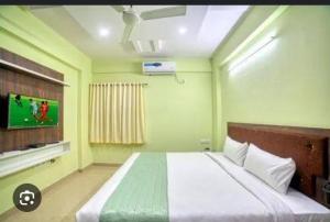 a bedroom with a large bed with a flat screen tv at hotel radiant in Mumbai