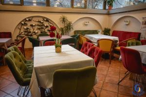 a restaurant with tables and chairs with flowers on them at GRAND G by GENERALTURIST GROUP in Skopje