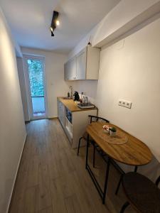 a kitchen with a wooden table and a table and chairs at Red Lake Apartman in Lacu Rosu