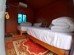 two beds in a room with red walls at Little Tay Homestay & Hostel in Làng Lap