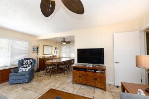 a living room with a flat screen tv and a chair at 315E Lower 315 Eucalyptus Lower in Avalon