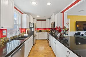 a large kitchen with white cabinets and red walls at 315E Upper 315 Eucalyptus Upper in Avalon