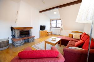 a living room with red furniture and a fireplace at Apartmaji Bar Smučar in Ribnica na Pohorju