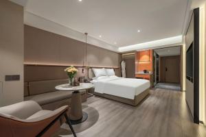 a hotel room with a bed and a table at 沃德酒店济南经十东路融创文旅城店 in Jinan