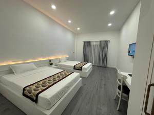 a hotel room with two beds and a television at The Aura Residence in Sihanoukville +4 photos