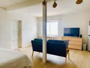 1 dormitorio con 2 sillas azules y TV en Peaceful Hideaway with Stunning View Beach Access, en Mae Nam