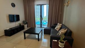 马六甲Happy Home @ Atlantis Residences [Pool View]的客厅里有一张沙发和一张桌子。