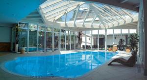 una grande piscina in un edificio con soffitto in vetro di B&B Villa Pattis a Vipiteno