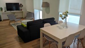 Una sala de estar con un sofá y una mesa con sillas. en Piso en el centro para 4 personas - Plaza Amboage - WIFI, en Ferrol