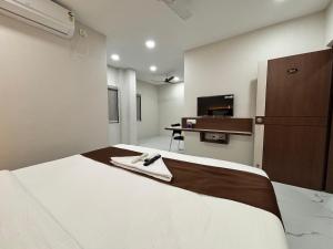 a bedroom with a bed with a robe on it at Hotel Mithra Grand in Hyderabad
