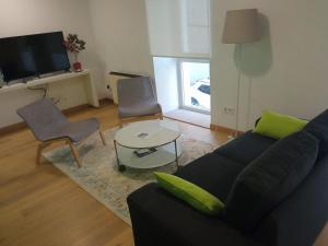 una sala de estar con un sofá y una mesa en Piso en el centro para 4 personas - Plaza Amboage - WIFI, en Ferrol