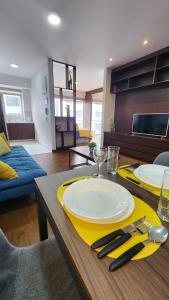 a dining table with a yellow plate and fork and knife at The Urban Echo in Cochabamba