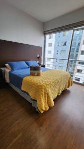 a bedroom with a large bed with a yellow blanket at The Urban Echo in Cochabamba