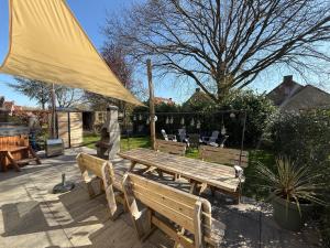 a wooden picnic table and benches in a yard at Pure Wellness Bungalows 52 Sauna&Hottub in Ewijk +61 photos
