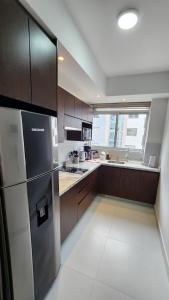 a kitchen with wooden cabinets and a stainless steel refrigerator at The Urban Echo in Cochabamba +23 photos