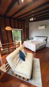 a living room with a couch and a bed at Chales da Trilha in Penha +75 photos