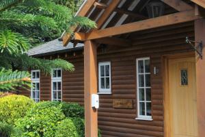 a log cabin with a porch and a door at Noble Fir Lodge - The Hollies Retreats in Oakmere