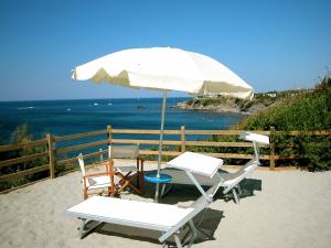duas cadeiras e um guarda-sol na praia em Villaggio Miramare em Livorno