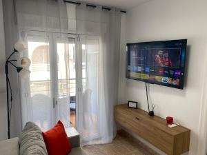 Una sala de estar con un televisor de pantalla plana en una pared. en Brisa del mar, en Torrevieja