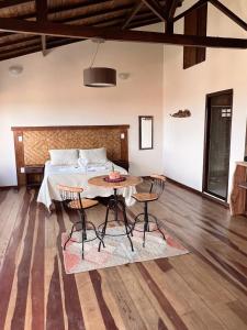 une chambre avec un lit, une table et des chaises dans l'établissement Vista da Serra, à Lavras Novas