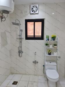 une salle de bain blanche avec toilettes et fenêtre dans l'établissement Wind alula, à Al-Ula 84 autres photos