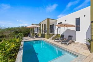 een zwembad voor een huis met parasols bij SERU40 Appartement 2 in Willemstad