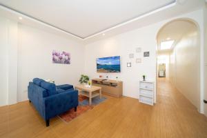 a living room with a blue couch and a table at Private patong home 4BR Jazzuci and 3 BR minimal, pick the house before book in Patong Beach