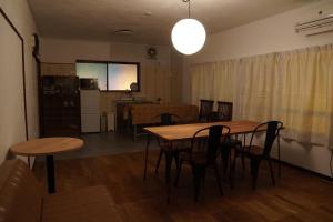 a living room with a table and chairs and a kitchen at Poo&Mee in Takemiya
