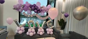 een kamer met paarse en roze ballonnen en een bank bij 7star in Guilin