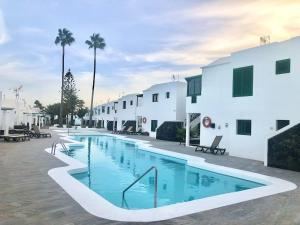 a swimming pool in front of a building at Beach house near the sea with pool in Puerto del Carmen