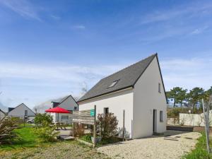 a white house with a black roof at Maison neuve avec terrasse pour 6 personnes in Bénodet